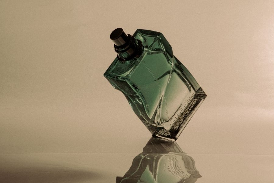 Elegant green perfume bottle showcasing fragrance layering techniques for longer lasting scent