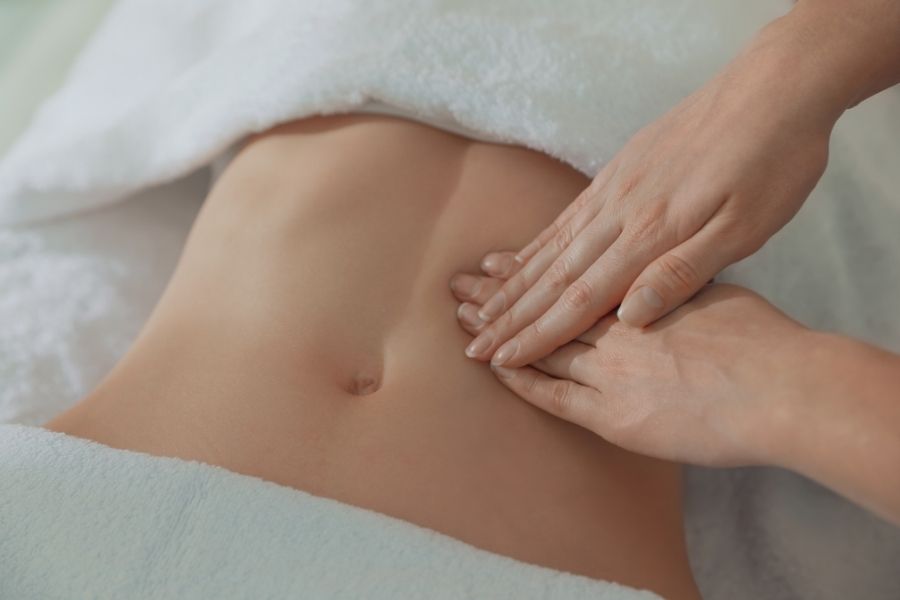 Professional lymphatic drainage massage technique on abdomen to reduce inflammation