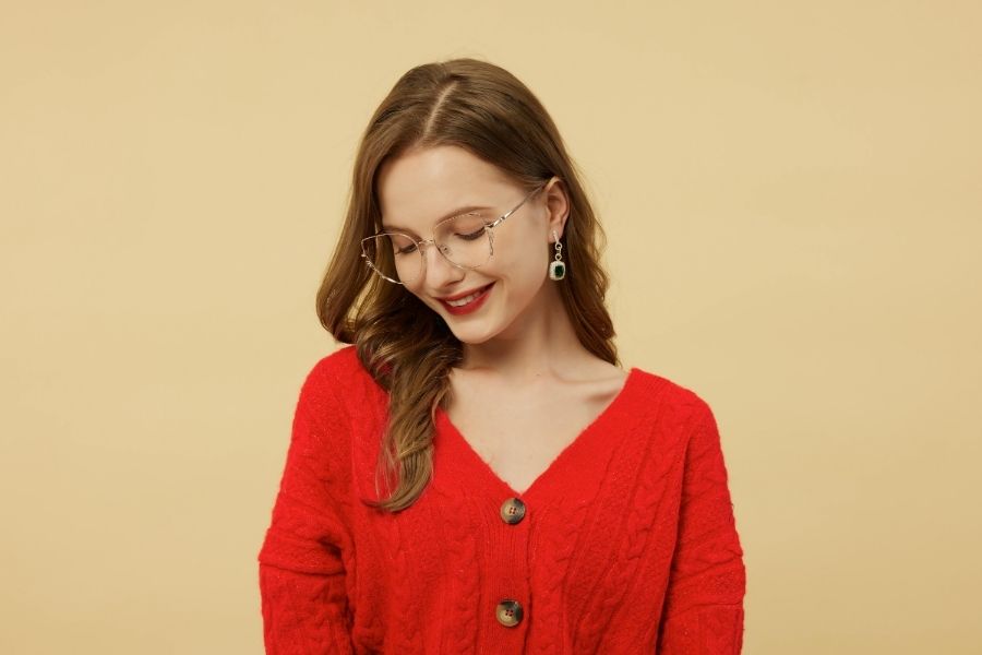 Woman wearing statement crystal drop earrings with bold red lipstick showcasing elegant jewelry trends