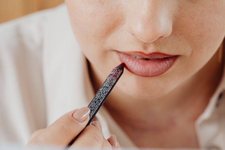 Woman applying advanced lip liner technique with precision liner tool for fuller lip appearance