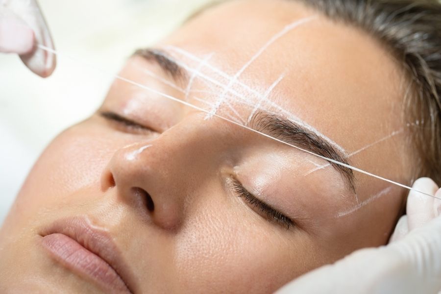 Professional brow lamination eyebrow treatment with precise mapping technique on client's face