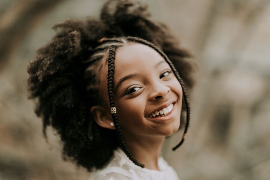 Young woman with beautiful natural curly hair and braided accent showcasing easy hairstyles