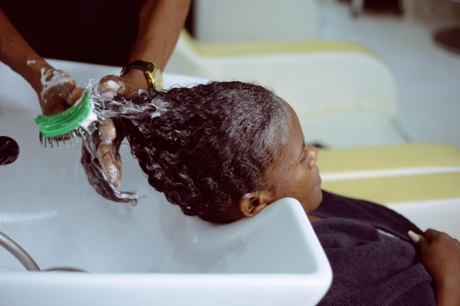 Professional salon hair treatment showing expert care compared to at-home hair color vs salon options