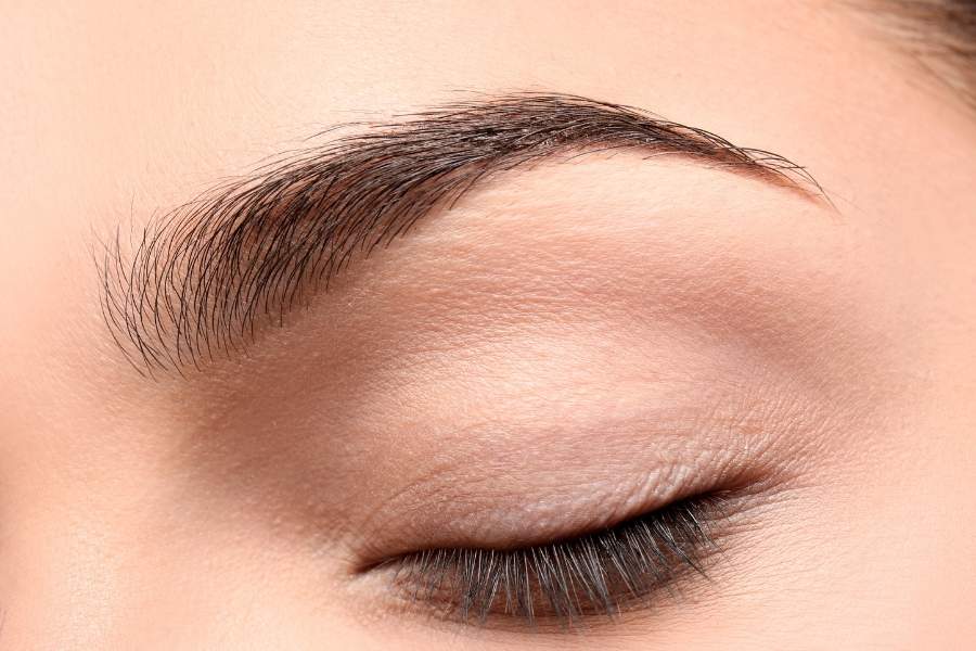 Close-up of naturally shaped perfect eyebrows with well-defined arch and groomed hair texture