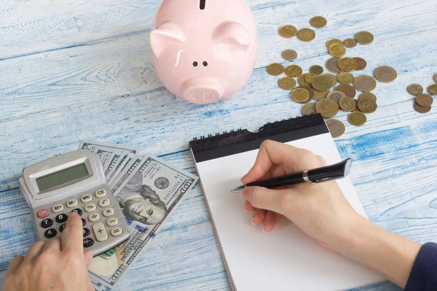 Wedding on a budget planning with calculator, piggy bank, and financial documents on wooden table