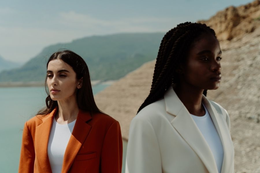 Two women in sustainable fashion blazers standing in natural desert landscape showcasing timeless ethical clothing