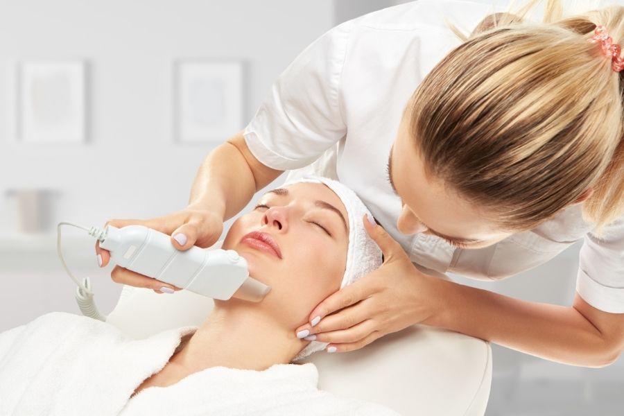 Professional aesthetic medicine treatment with advanced skincare device in modern clinic setting
