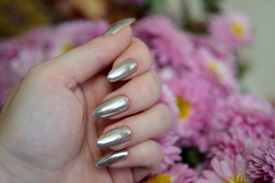 Stunning silver chrome nail trends showcased against pink floral background