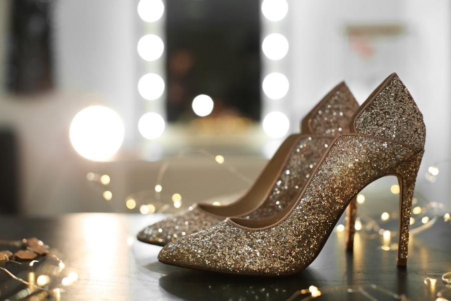 Sparkling gold comfortable heels with glitter finish surrounded by warm bokeh lights