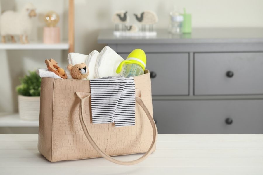 Stylish beige tote bag showcasing diaper bag beauty with baby essentials in nursery setting