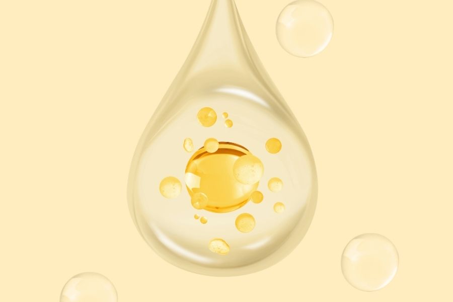 Golden oil droplet illustration showing niacinamide layering serum texture