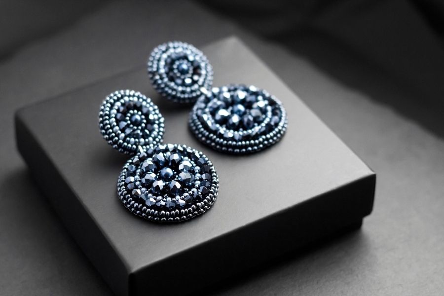 Elegant blue beaded statement earrings with crystals displayed on black jewelry box