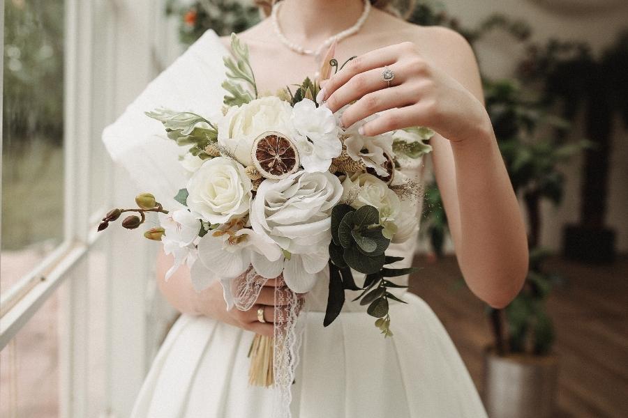 Bride holding elegant white bouquet prepared for any bridal emergency on wedding day