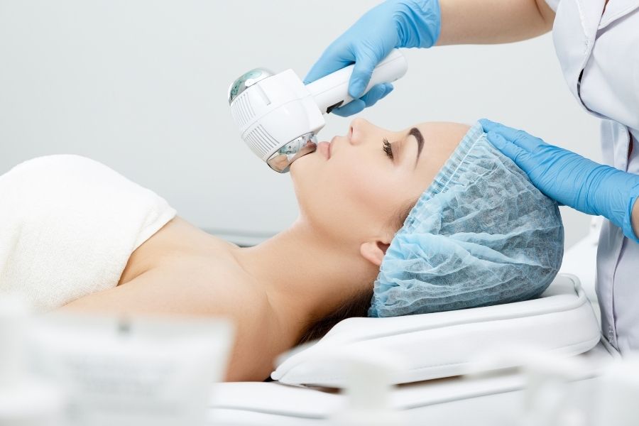 Professional cold therapy facial treatment being performed in medical spa setting