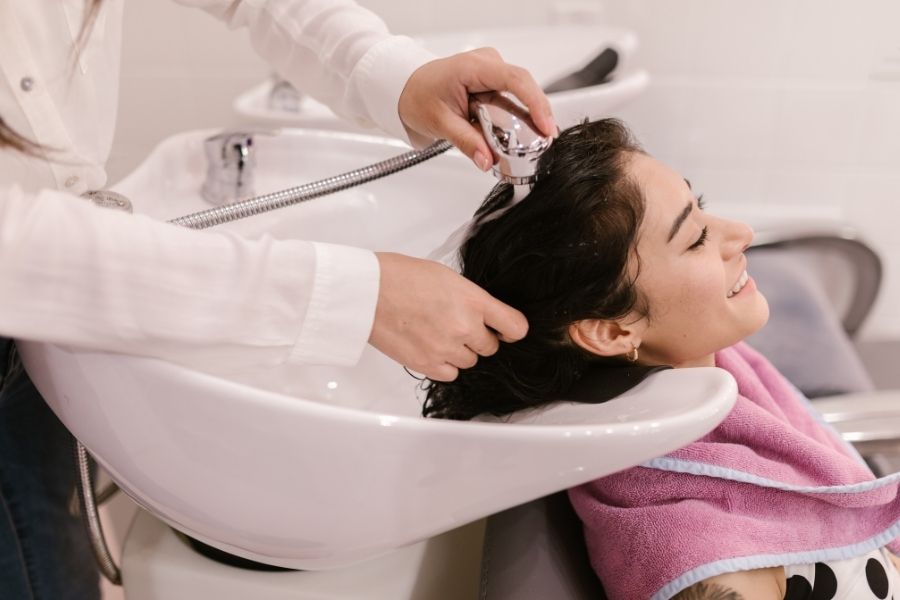 Professional hair slugging treatment being applied at salon with specialized equipment and care