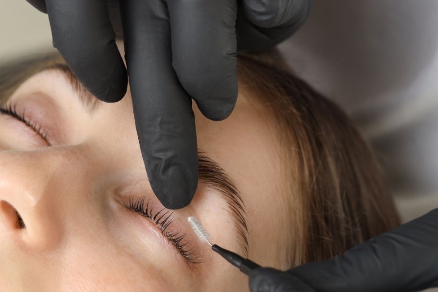 Professional lash lamination procedure being performed with precision tools on client's eyelashes