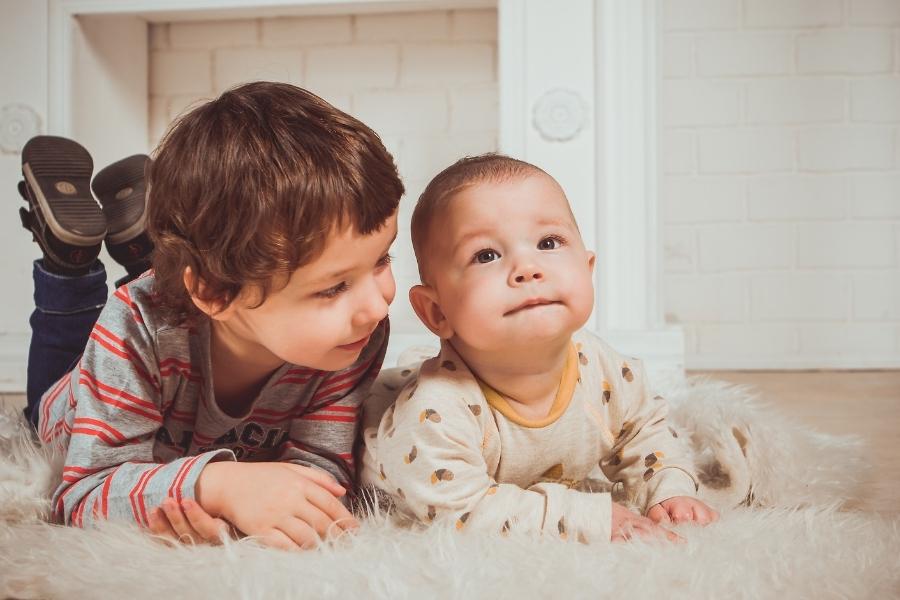 Two young children playing together at home in environment safe from toddler-safe makeup concerns
