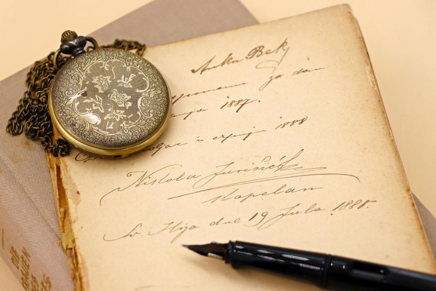 Ornate vintage watch with chain displayed on handwritten letter with fountain pen