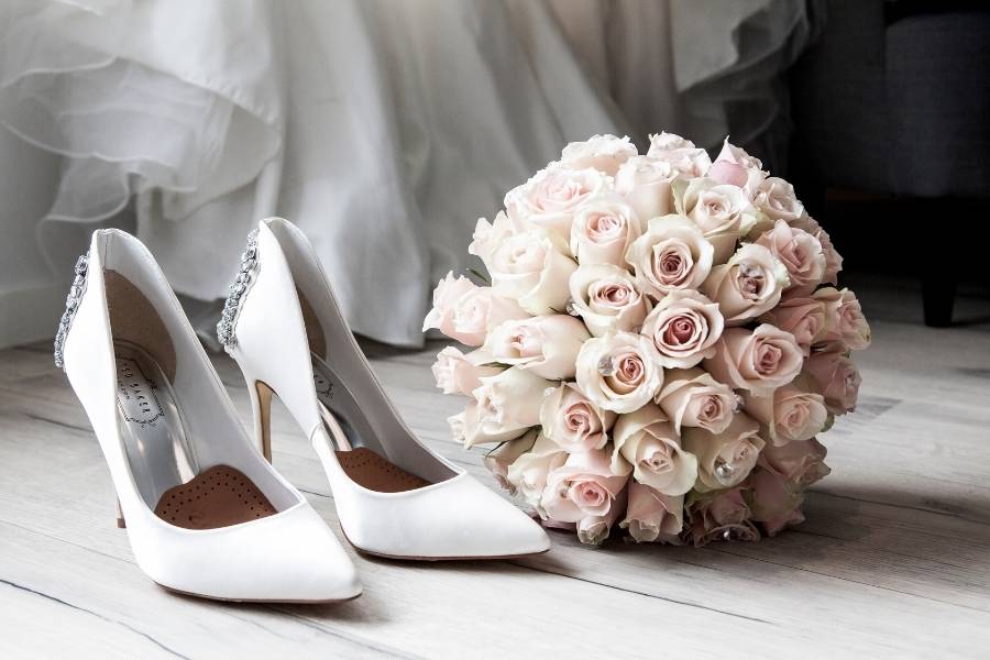 Elegant white wedding shoes and pink rose bouquet capturing the essence of wedding morning preparations