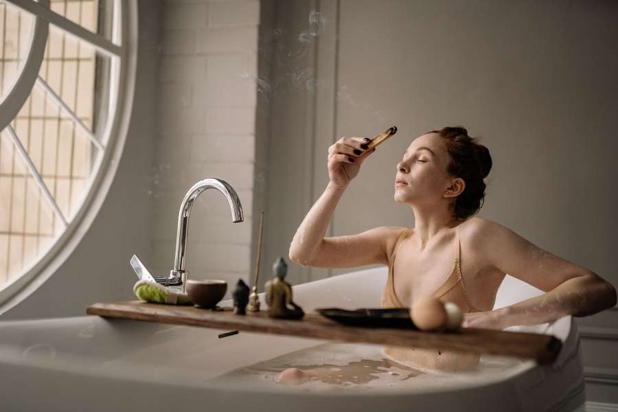 A woman relaxing in a bathtub during her evening wind down routine.
