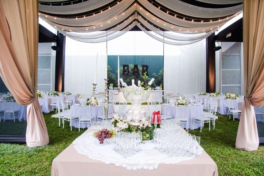 An outdoor marquee tent decorated for a celebration among alternative wedding venues